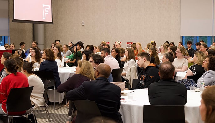 Fairfield students (undergrad and grad) listening intently during a lecture-style event.