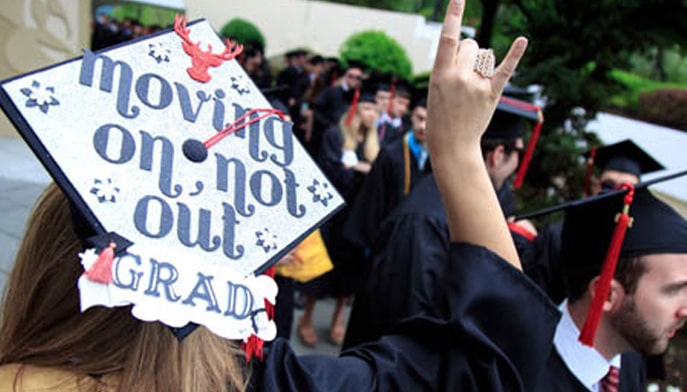 picture of a decorated graduation cap that reads "moving on, not out"