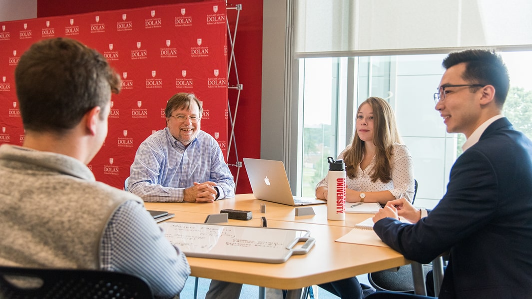 A group of students sit and collaborate at a table.