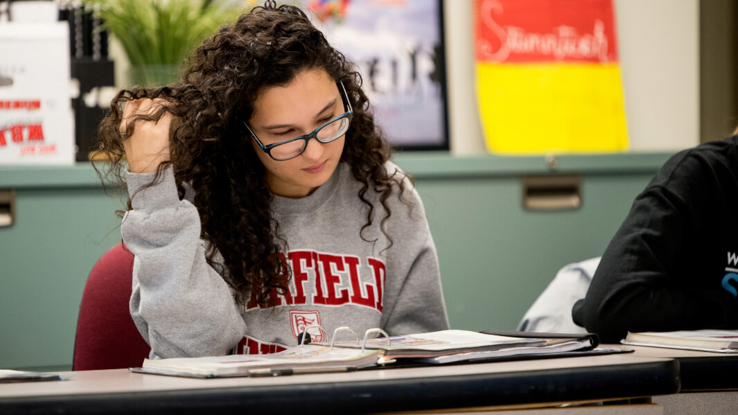 A student sits at a desk.