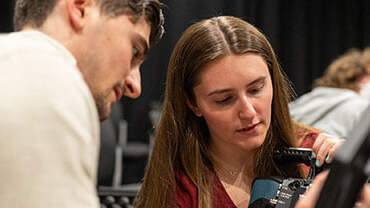 Two students looking at camera footage together. 