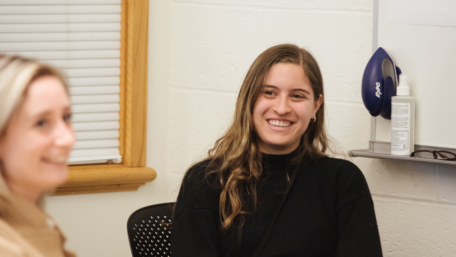 Two students smile.