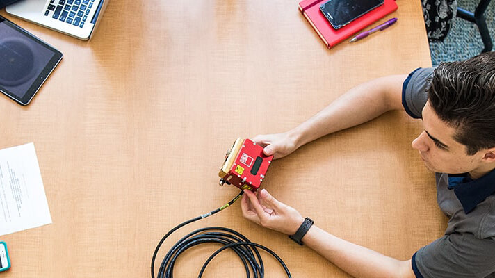 Software engineering student holding a device.