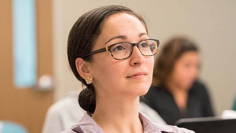 A student in glasses looks forward.