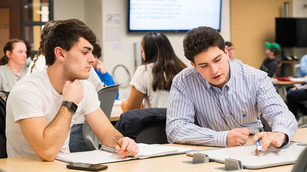 A group of students sit in a classroom looking forward.