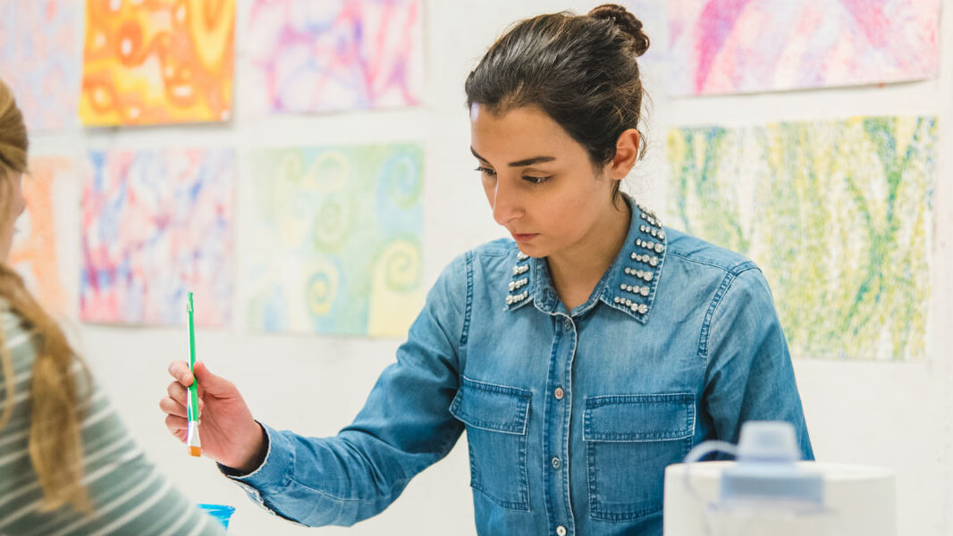 A student paints in a studio.