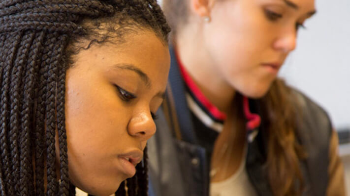 Two students sit in a classroom.