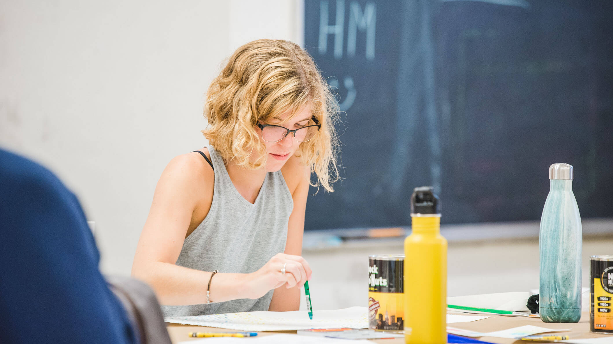 A student paints a piece of paper.