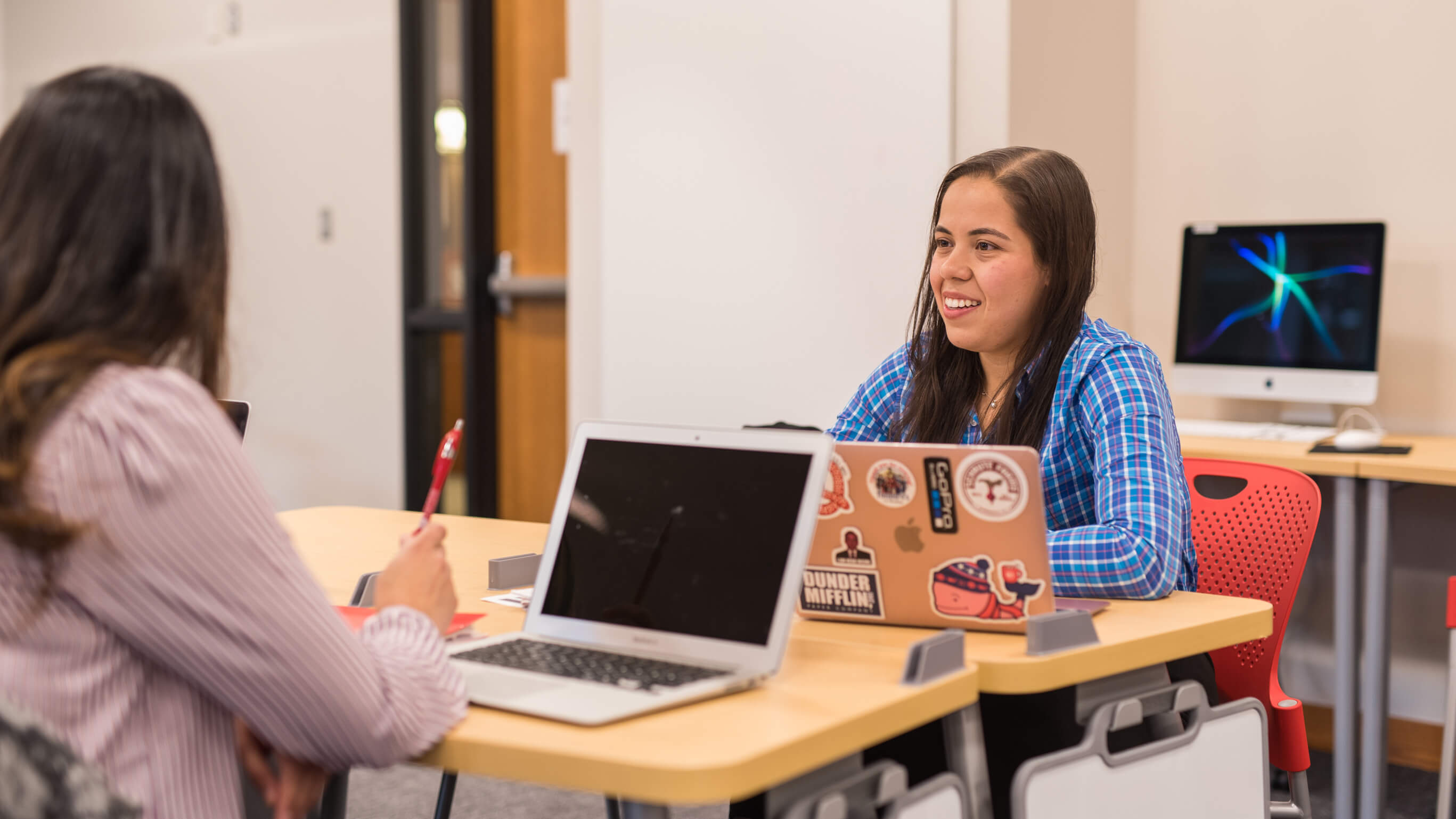 Two students sit at a desk.