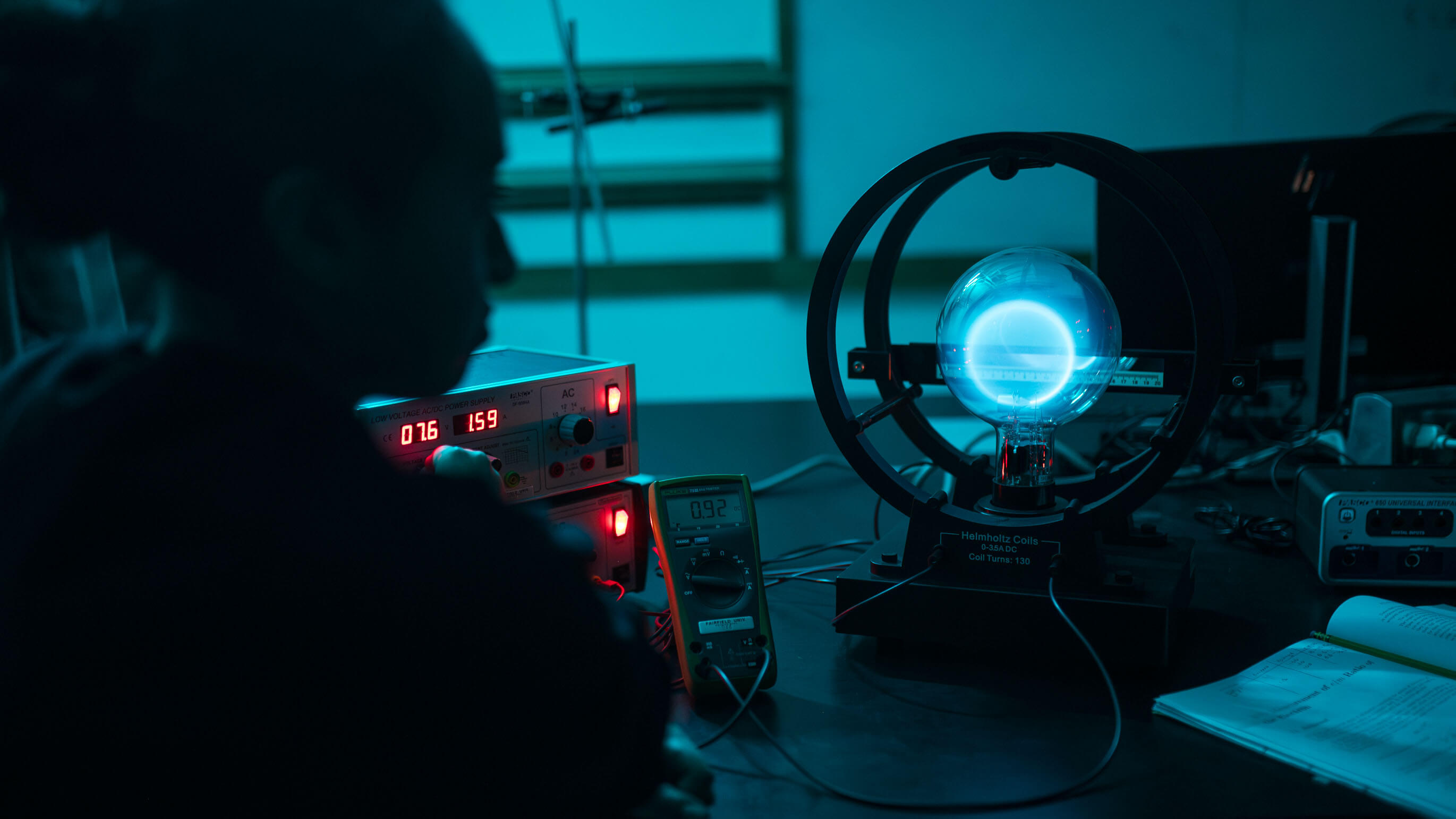 A student works on a phsyics machine in the dark.