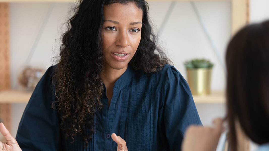 A woman talking to her peer in a caring manner.