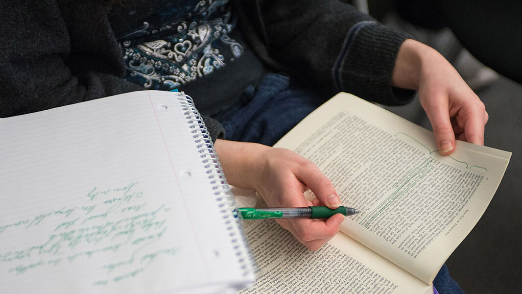 Someone writing in a notebook or journal. 