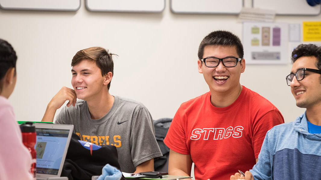 Students in classroom collaborating and laughing. 