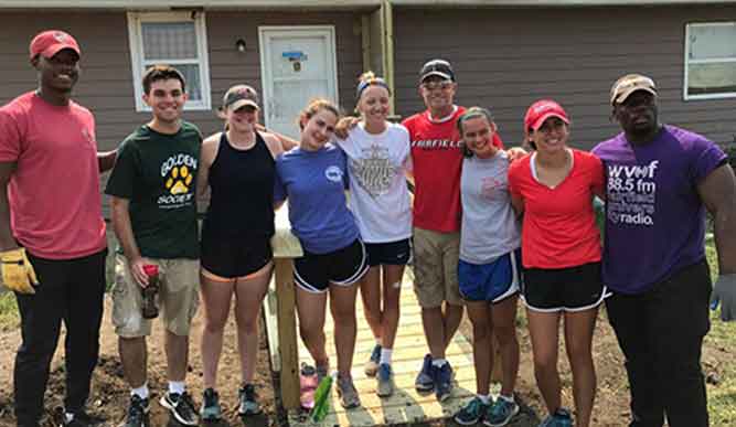 Student volunteers posing for a photo outdoors. 