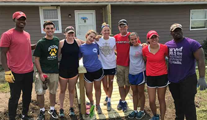 Students standing together and posing for a picture outdoors. 