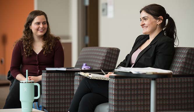 Two students sitting in a classroom. 