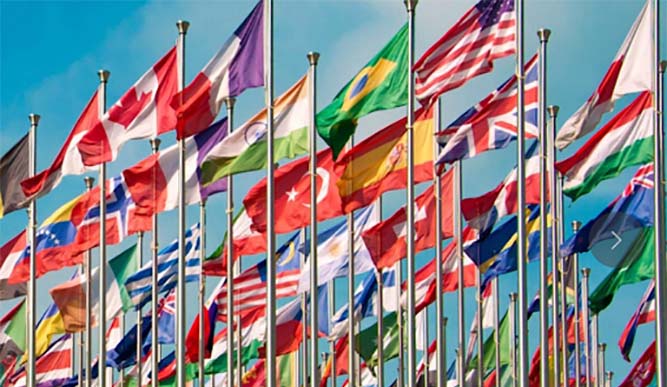 A large collection of international flags waving in the wind. 