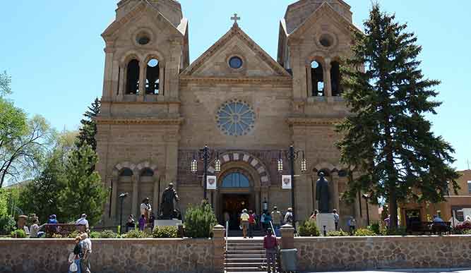 An exterior shot of a stone building with a cross. 