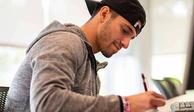 A student takes notes during a Dolan class.