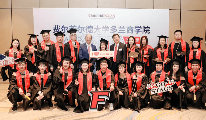 A group of graduates wearing caps and gowns, celebrating their academic achievements together indoors.