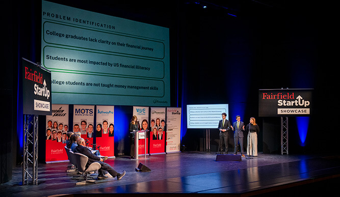 Student StartUp team presenting their idea to a panel of judges.