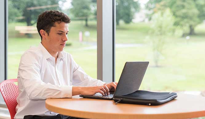 Student working at table in library.