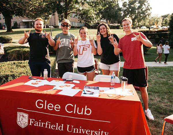 Five students standing outside in front of their student organization club table.